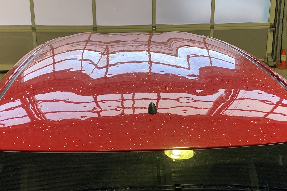 Rood dakpaneel van een Toyota Aygo zwaar beschadigd met grote hageldeuken